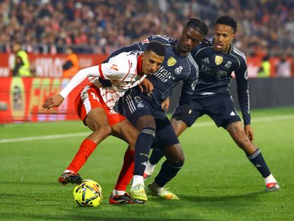 عز الدين أوناحي لاعب جيرونا يحاول الاحتفاظ بالكرة وسط مضايقة من إدواردو كامافينغا لاعب ريال مدريد الإسباني 0 30 نوفمبر 2025 - REUTERS