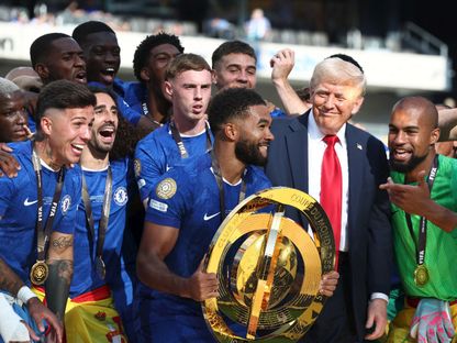 الرئيس الأميركي دونالد ترمب مع لاعبي تشيلسي بعد تسليمهم كأس العالم للأندية إثر فوزهم على باريس سان جيرمان - 13 يوليو 2025 - Reuters
