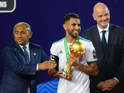 رئيس الفيفا جياني إنفانتينو يمين ورئيس الاتحاد الإفريقي لكرة القدم أحمد أحمد يسلم كأس  إفريقيا للمهاجم الجزائري رياض محرز  - AFP
