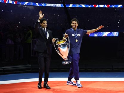 رئيس باريس سان جيرمان ناصر الخليفي وماركينيوس يحملان كأس دوري أبطال أوروبا خلال احتفال في "بارك دي برانس" - 1 يونيو 2025 - Reuters
