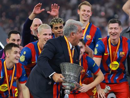 رئيس برشلونة جوان لابورتا يحتفل مع لاعبيه بلقب كأس السوبر الإسباني بعد تخطي ريال مدريد في النهائي - 12 يناير 2026 - Reuters