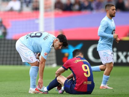 روبرت ليفاندوفسكي مهاجم برشلونة يجلس على أرض الملعب بعد إصابته في مباراة سيلتا فيغو في الدوري الإسباني - 19 إبريل 2025 - REUTERS