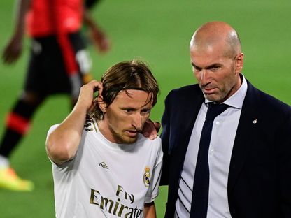 لاعب نادي ريال مدريد، الكرواتي لوكا مودريتش، مع مدربه الفرنسي زين الدين زيدان - AFP