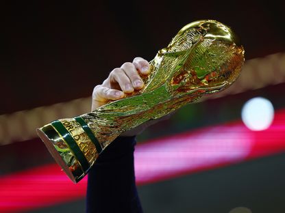 مشجّع يحمل نسخة من كأس العالم قبل المباراة بين فرنسا والمغرب في نصف النهائي - 14 ديسمبر 2022 - Reuters 