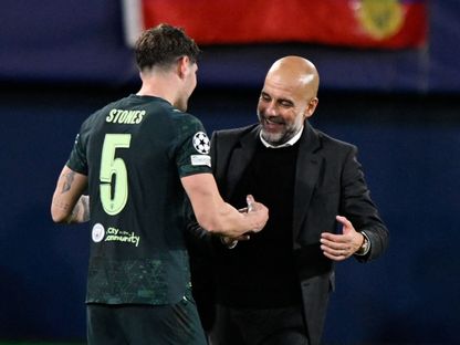 مدرب مانشستر سيتي بيب غوارديولا يحتفل مع لاعبه جون ستونز بعد الفوز على فياريال في دوري أبطال أوروبا - 21 أكتوبر 2025 - Reuters
