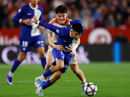 لاعب إشبيلية خواكين مارتينيز أوسو يجذب جناح أتلتيكو مدريد تياغو ألمادا في مباراة بالدوري الإسباني - 11 أبريل 2026 - Reuters