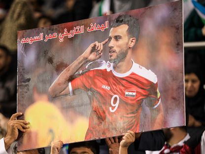مشجعو سوريا يرفعون صورة الهداف التاريخي للمنتخب عمر السومة خلال مواجهة أوزبكستان في كأس آسيا - 13 يناير 202 - awp