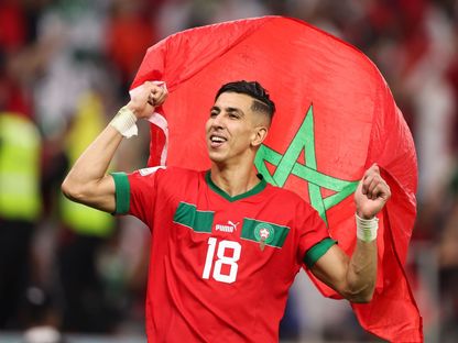 لاعب المنتخب المغربي جواد الياميق يحمل علم بلاده بعد التأهل إلى نصف نهائي كأس العالم ضد البرتغال - 10 ديسمبر 2022 - Reuters