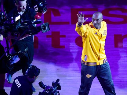 كوبي براينت يلوح بيده للجماهير في آخر مباراة له مع لوس أنجلوس ليكرز في 13 أبريل 2016 - AFP