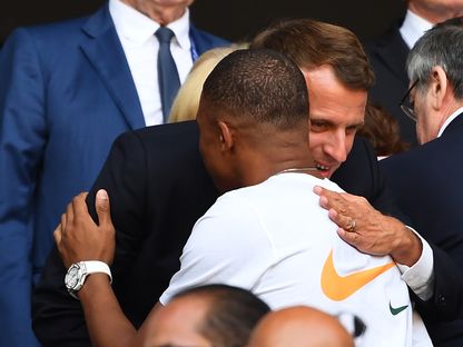 الرئيس الفرنسي إيمانويل ماكرون رفقة نجم منتخب فرنسا مبابي - AFP