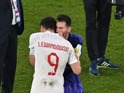 الأرجنتيني ليونيل ميسي يهمس في أذن البولندي روبرت ليفاندوفسكي بعد المباراة - 30 نوفمبر 2022 - AFP