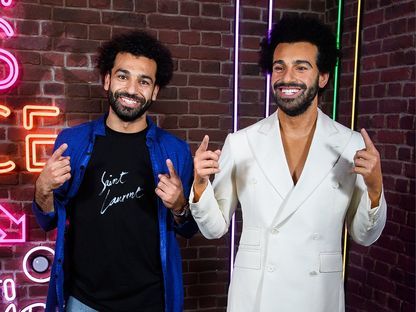 محمد صلاح (يسار) يقف بجانب تمثاله في متحف مدام توسو في لندن - TWITTER/@MadameTussauds