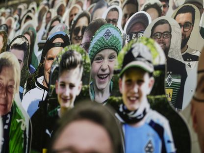 مجسمات ورقية مثبتة على المدرجات تمثّل جماهير بوروسيا مونشغلادباخ - AFP