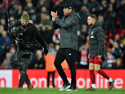 أحد مصوري مباريات الدوري الإنجليزي إلى جانب مدرب ليفربول الألماني يورغن كلوب - AFP