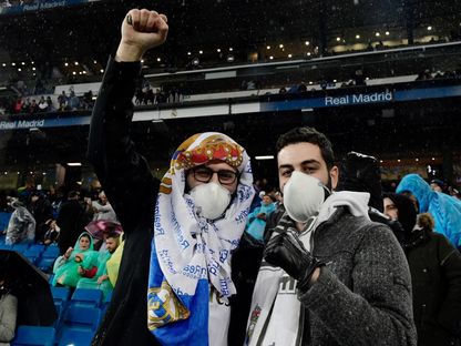 اثنان من مشجعي ريال مدريد يرتدون كمامات في مبارة سابقة يوم 1 مارس 2020 - AFP