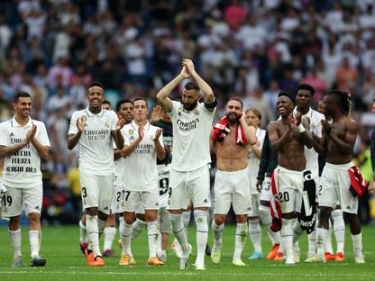 مهاجم ريال مدريد كريم بنزيما يصفق للجمهور محاطاً بزملائه في نهاية مباراته الأخيرة ضد أتلتيك بلباو - 4 يونيو 2023 - AFP