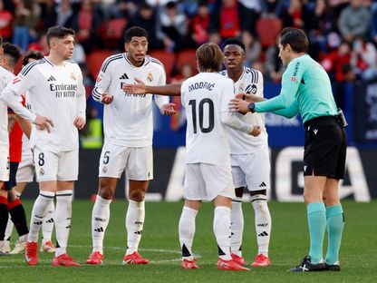 لاعبو ريال مدريد يتجمعون حول الحكم بعد طرد جود بيلينغهام أمام أوساسونا - 15 فبراير 2025 - Reuters