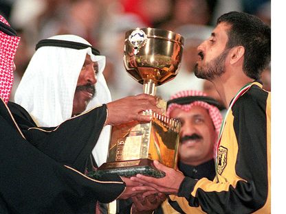 ولي العهد الكويتي الشيخ سعد العبدالله الصباح، يسلم كأس ولي العهد لكرة القدم لقائد فريق القادسية، عبيد الشمري - AFP