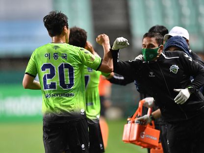 لي دونج جوك يحتفل بتسجيل أول هدف بعد استئناف الدوري الكوري مع زملائه على مقاعد البدلاء - AFP