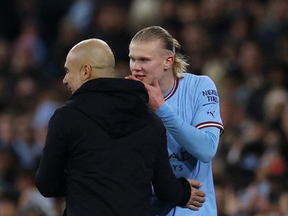 إيرلينغ هالاند مهاجم مانشستر سيتي يتحدث مع مدربه بيب غوارديولا في مواجهة لايبزيغ - 14 مارس 2023 - REUTERS