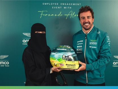 السائق الإسباني فرناندو ألونسو مع الفنانة السعودية سارة تركستاني صاحبة التصميم الخاص للخوذة - 18 أبريل 2025 - X/aramco