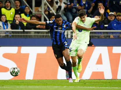 دينزل دومفريز لاعب إنتر ميلان في صراع على الكرة مع جيرارد مارتن لاعب برشلونة خلال مواجهة الفريقين في إياب نصف نهائي دوري أبطال أوروبا - 6 مايو 2025 - Reuters