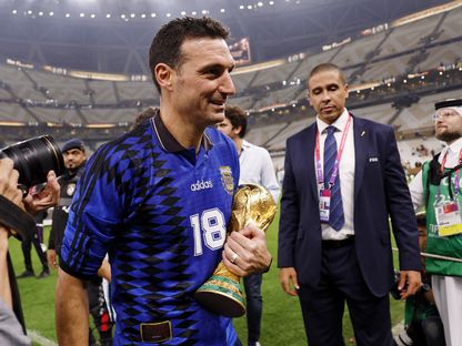 المدرب الأرجنتيني ليونيل سكالوني يحمل كأس العالم في ملعب لوسيل - Reuters