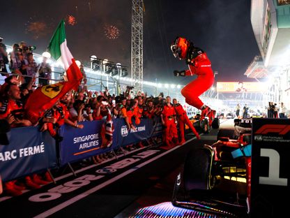 كارلوس ساينز يقفز من سيارته فيراري احتفالا بفوزه بسباق جائزة سنغافورة الكبرى للفورمولا 1 - 17 سبتمبر 2023 - REUTERS
