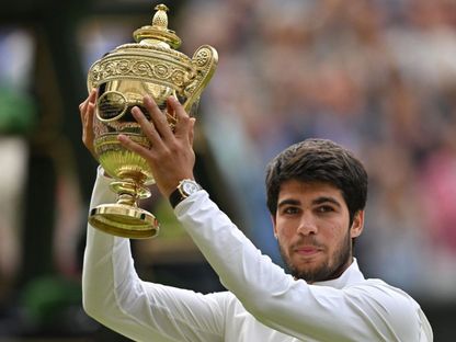 كارلوس ألكاراز يرفع كأس بطولة ويمبلدون بعد فوزه على نوفاك دجوكوفيتش - 16 يوليو 2023 - AFP