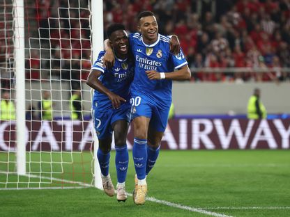 كيليان مبابي يحتفل مع فينيسيوس بتسجيله هدفاً لريال مدريد في مرمى أولمبياكوس بدوري أبطال أوروبا - 26 نوفمبر 2025 - REUTERS