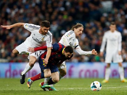 تشابي ألونسو ولوكا مودريتش يحاولان افتكاك الكرة من ليونيل ميسي خلال مباراة ريال مدريد وبرشلونة في الدوري الإسباني - 24 مارس 2014 - REUTERS
