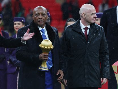 رئيس الاتحاد الإفريقي لكرة القدم باتريس موتسيبي يحمل كأس أمم إفريقيا أثناء سيره بجانب رئيس الفيفا جياني إنفانتينو خلال مراسم التتويج - 18 يناير 2026 - Reuters