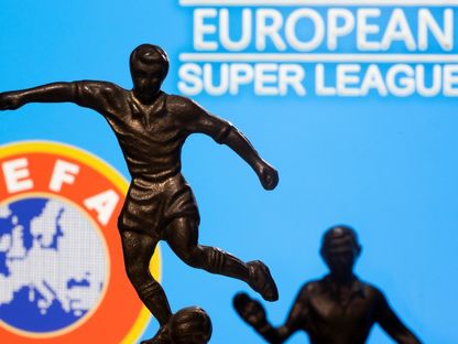 تمثال معدني للاعب كرة قدم وخلفه شعاري السوبر ليغ والاتحاد الأوروبي لكرة لقدم - REUTERS