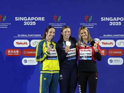 كاتي ليديكي (في المنتصف) تحتفل بذهبية سباق 800 متر حرة مع الأسترالية لاني باليستر والكندية سمر ماكنتوش - 2 أغسطس 2025 - Reuters