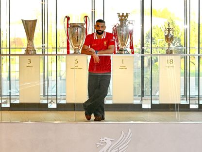محمد صلاح يتلقط صورة مع ألقاب ليفربول - X/@LFC