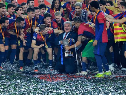 رئيس برشلونة جوان لابورتا يحتفل مع لاعبيه بكأس السوبر الإسباني بعد الفوز على ريال مدريد - 12 يناير 2025 - Reuters