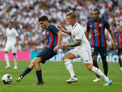 بيدري لاعب برشلونة يمرر الكرة أمام توني كروس نجم ريال مدريد في الدوري الإسباني - 16 أكتوبر 2022 - Reuters