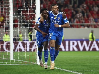 كيليان مبابي يحتفل مع فينيسيوس بتسجيله هدفاً لريال مدريد في مرمى أولمبياكوس بدوري أبطال أوروبا - 26 نوفمبر 2025 - REUTERS