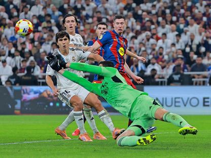 تيبو كورتوا حارس ريال مدريد يتصدى لكرة أمام أنظار روبرت ليفاندوفسكي في نهائي السوبر الإسباني - 11 يناير 2026 - Reuters