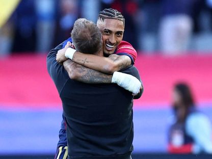 رافينيا يعانق هانزي فليك بعد صناعته لهدف وتسجيله لهدفين أمام سيلتا فيغو في الليغا 19-4-2025 - Reuters