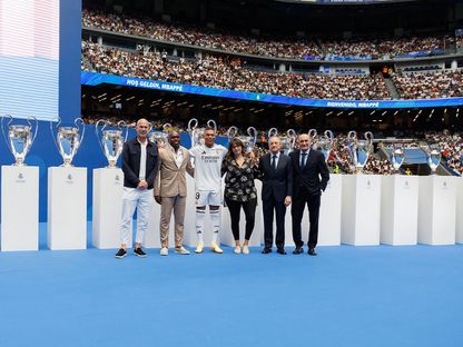 كيليان مبابي متوسّطاً والديه ورئيس ريال مدريد فلورنتينو بيريز وزين الدين زيدان وخوسيه مارتينيز "بيرّي" الرئيس الفخري للنادي في "سانتياغو برنابيو" - 16 يوليو 2024 - realmadrid.com