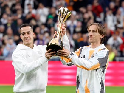 لوكا مودريتش ولوكاس فاسكيز لاعبا ريال مدريد يحملان كأس إنتركونتيننتال قبل مباراة إشبيلية في الليغا - 22 ديسمبر 2024 - Reuters