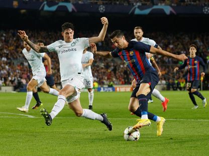 أليساندرو باستوني مدافع إنتر ميلان يحاول التصدي لروبرت ليفاندوفسكي مهاجم برشلونة - 12 أكتوبر 2022 - Reuters