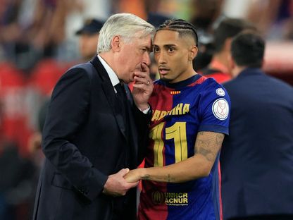 كارلو أنشيلوتي مدرب ريال مدريد يتحدث مع رافينيا مهاجم برشلونة بعد خسارة نهائي كأس ملك إسبانيا - 26 أبريل 2025 - Reuters