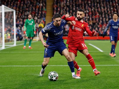 محمد صلاح وأشرف حكيمي في صراع على الكرة خلال مواجهة ليفربول وباريس سان جيرمان في دوري أبطال أوروبا - 11 مارس 2025 - REUTERS