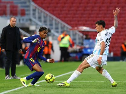 لامين يامال لاعب برشلونة يمر من أحد لاعب أوفييدو أمام هانزي فليك - 25 يناير 2026 - Reuters