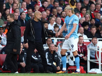 بيب غوارديولا مدرب مانشستر سيتي يتحدث مع لاعبه إيرلينغ هالاند بعد استبداله بمواجهة أرسنال في الدوري الإنجليزي الممتاز - 21 سبتمبر 2025 - Reuters