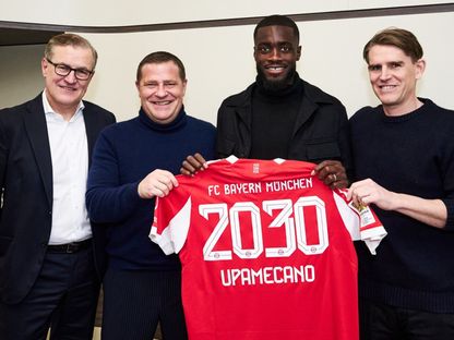 المدافع الفرنسي دايوت أوباميكانو يتوسط مسؤولي بايرن ميونيخ بعد تجديد عقده مع النادي حتى 2030 - 13 فبراير 2026 - facebook/fcbayern.en