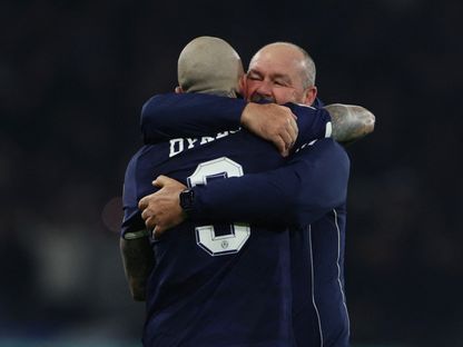 ستيف كلارك مدرب أسكتلندا يعانق لاعبه ليندون ديكس عقب التأهل إلى كأس العالم على حساب الدنمارك - 18 نوفمبر 2025 - REUTERS