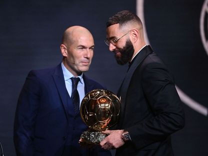 كريم بنزيما مهاجم ريال مدريد الإسباني يتسلم الكرة الذهبية من مواطنه زين الدين زيدان - 17 أكتوبر 2022 - AFP